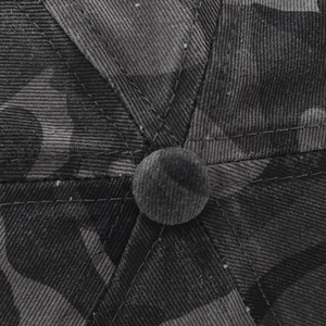Close-up of camouflage baseball cap crown featuring premium stitching and button detail