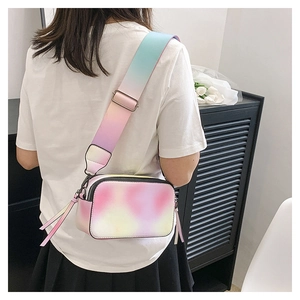 Rainbow gradient camera bag with wide strap worn as a crossbody purse for women