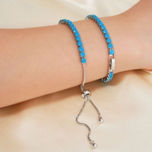Adjustable silver bracelet set featuring blue turquoise beads on luxury silk background