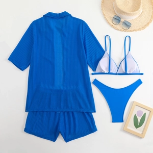 Detailed flat lay of blue ribbed four-piece swimsuit set with shirt and beach accessories