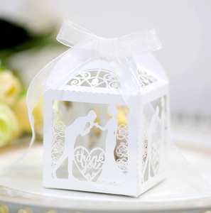 Macro shot of white laser-cut wedding favor box with ribbon and thank you text