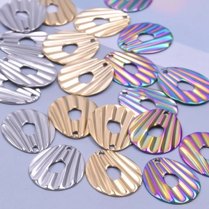 Détail de pendentifs ovales arc-en-ciel et dorés avec texture ondulée et centre évidé