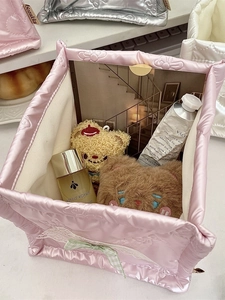 Pink quilted satin organizer box with lace bow detail for desktop cosmetic storage
