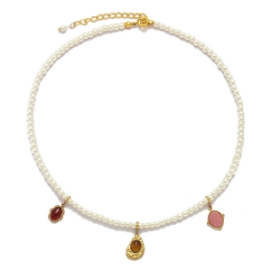 Detailed view of pearl necklace featuring red, amber and pink teardrop stone pendants
