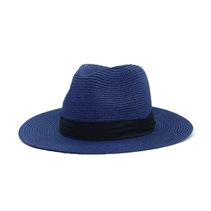 Detail of navy blue straw fedora with woven texture and black ribbon band for sun protection