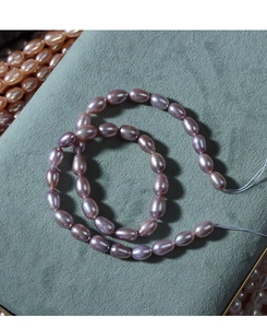 Close-up of natural purple oval freshwater pearls on green velvet for jewelry making