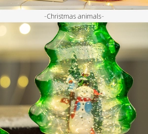 Detailed view of a green glass Christmas tree snow globe with a snowman and glitter