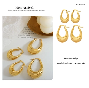 Detail view of large and small gold U-shaped drop earrings with high-polish metallic finish
