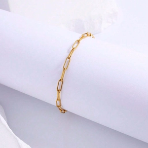 Elegant gold paperclip chain bracelet in stainless steel on white minimalist display