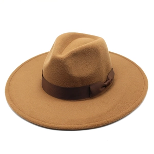 Detail of camel wool fedora hat featuring wide brim and dark brown satin ribbon decoration