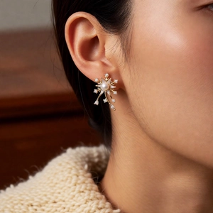 Gros plan de boucles d'oreilles flocon de neige avec perle blanche et cristaux sur l'oreille