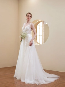 Detailed close-up of V-neck lace bodice and layered tulle skirt on a white bridal gown