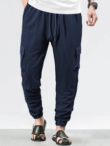 Close-up of deep blue waffle textured fabric on men's drawstring cargo pants