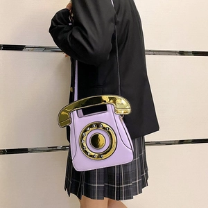 Close-up of retro lilac telephone crossbody bag featuring a golden rotary dial design