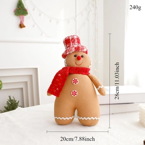 Detail of Christmas gingerbread man plush doll with red checkered bow on white table