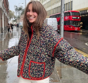 Detail of navy quilted jacket with red berry print and contrast piping on the street