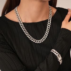 Silver iced-out Cuban link necklace and bracelet set worn by a female model