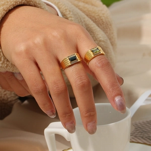 Close-up of 18K gold plated stainless steel rings with black and green baguette stones