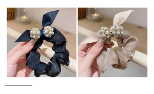 Détail de chouchous en satin avec perles et strass en noir et couleur champagne
