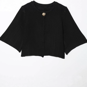 Women's black knit cardigan with round neck, gold button, and cape sleeves in minimalist style