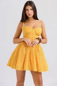 Close-up of yellow lace floral texture and button details on the mini A-line dress