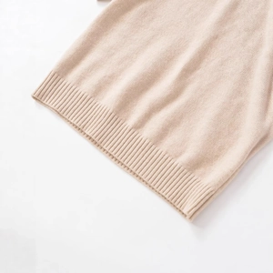 Close-up of beige round neck knit sweater featuring soft texture and ribbed hem detail
