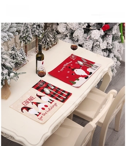 Close-up of Christmas placemats featuring gnomes and red black plaid on a festive table