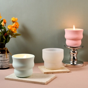 Dettaglio stampo in silicone ondulato e tazze in gesso per candele con trama a onde