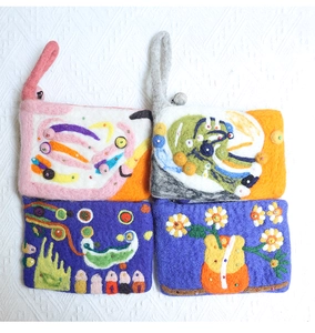 Detail of colorful handmade wool felt bags with 3D floral embroidery and beaded patterns