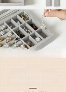 Detail view of grey velvet jewelry box with glass window and adjustable compartments for rings