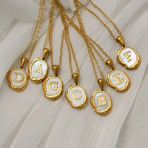 Gold plated titanium steel shell initial necklace featuring irregular lava texture edges