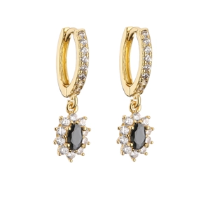 Macro view of gold hoop earrings with black starburst pendants and white zircon details
