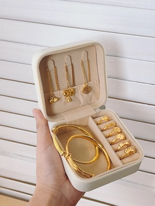 Macro view of portable cream jewelry box showing necklace hooks and ring storage slots
