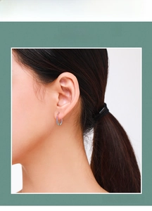 Close-up of s925 silver rainbow hoop earring with colorful zircon stones on model's ear