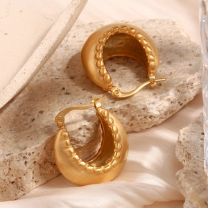 Close-up of 18K gold plated stainless steel hoops with bead trim on natural stone