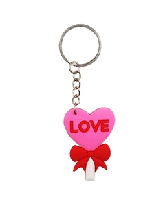 Detail of pink PVC heart keychain with red bow and LOVE text on white background