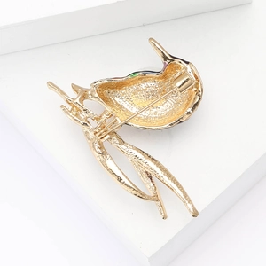 Detailed back view of gold alloy woodpecker brooch with rhinestone and enamel finish