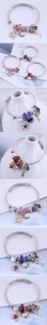 Detail of beaded steel wire bracelets with bear and heart charms in pink, blue and red