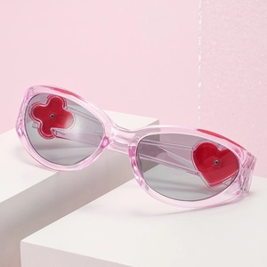 Pink heart-shaped Y2K sunglasses with translucent frames and clover detailing