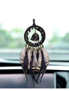 Detail view of a vintage car hanging ornament with natural stone, feathers and bells