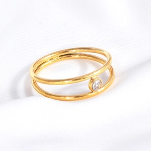Detailed close-up of a double-layer gold titanium steel ring with sparkling zircon inlay