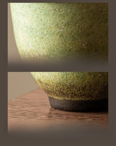Macro shot of kiln-baked ceramic tea cup with green crystalline glaze and smooth base
