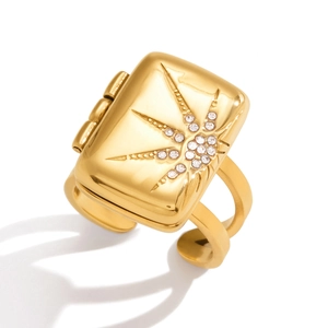 Detailed view of an 18K gold-plated starburst square locket ring with white rhinestones