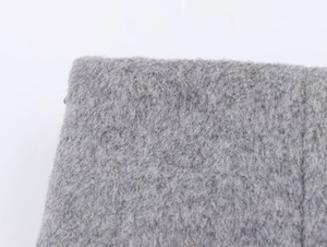Detailed close-up of thick grey faux fur fabric with plush texture for women outerwear