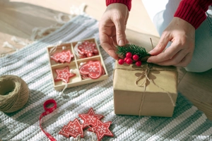 Detailed view of Christmas berry pine needles and red wooden ornaments for gift wrapping
