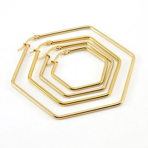 Golden titanium steel hexagonal hoop earrings set in four different sizes on white