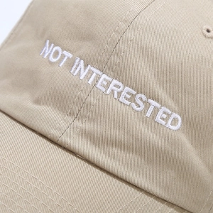 Khaki cotton baseball cap with white NOT INTERESTED letter embroidery detail