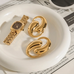 Detailed view of vintage gold square watch and twisted double hoop earrings set