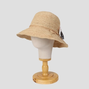 Close-up of hand-woven raffia sun hat with delicate texture on a display mannequin