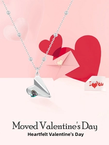 Close-up of 925 silver paper plane necklace with colorful heart gemstone on pink backdrop